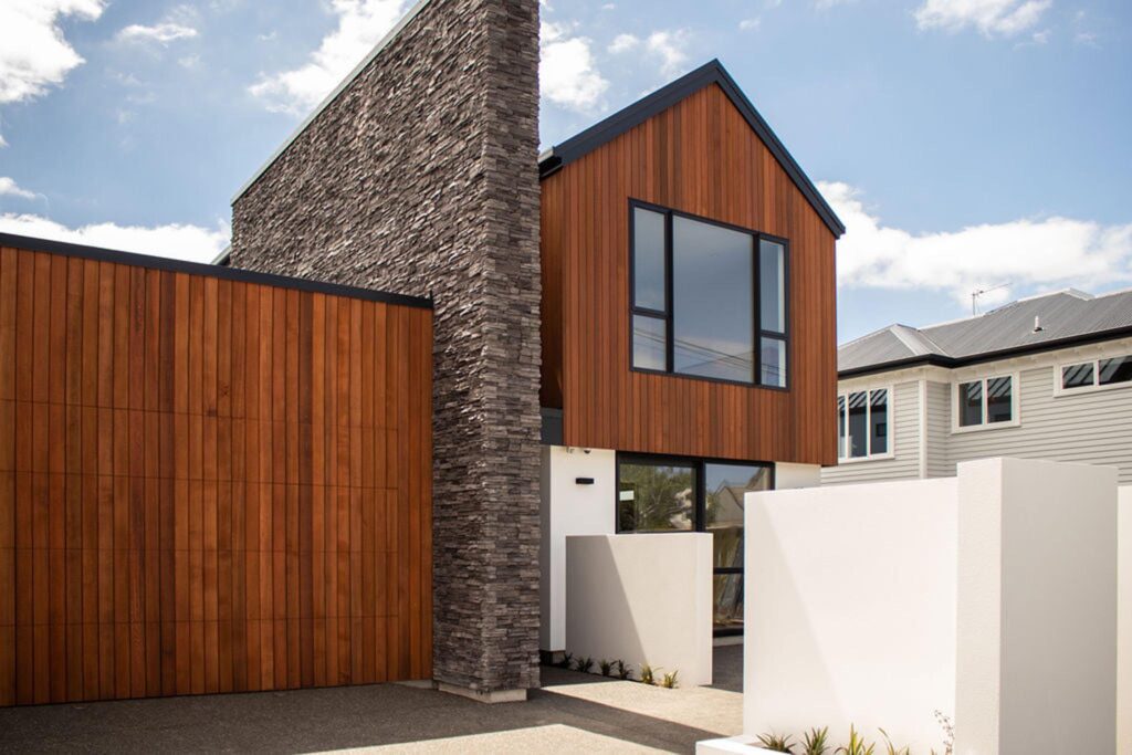 Front view of a contemporary home with timber and stone exterior finishes, built by Stanton Builders, Christchurch master builders specialising in new builds, house extensions, and full-service home renovation contractors.