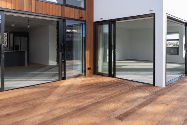 Outdoor timber decking area connecting indoor living spaces by Stanton Builders