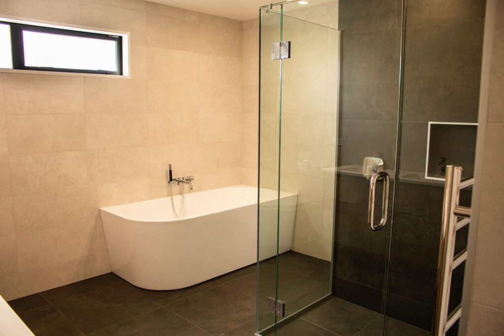 Freestanding bathtub and glass shower in a newly renovated bathroom by Stanton Builders