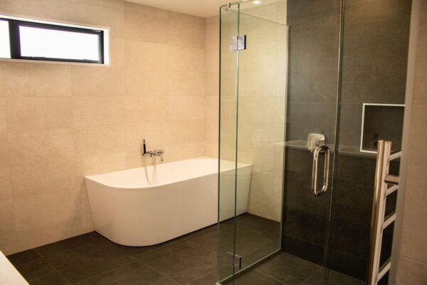 Freestanding bathtub and glass shower in a newly renovated bathroom by Stanton Builders