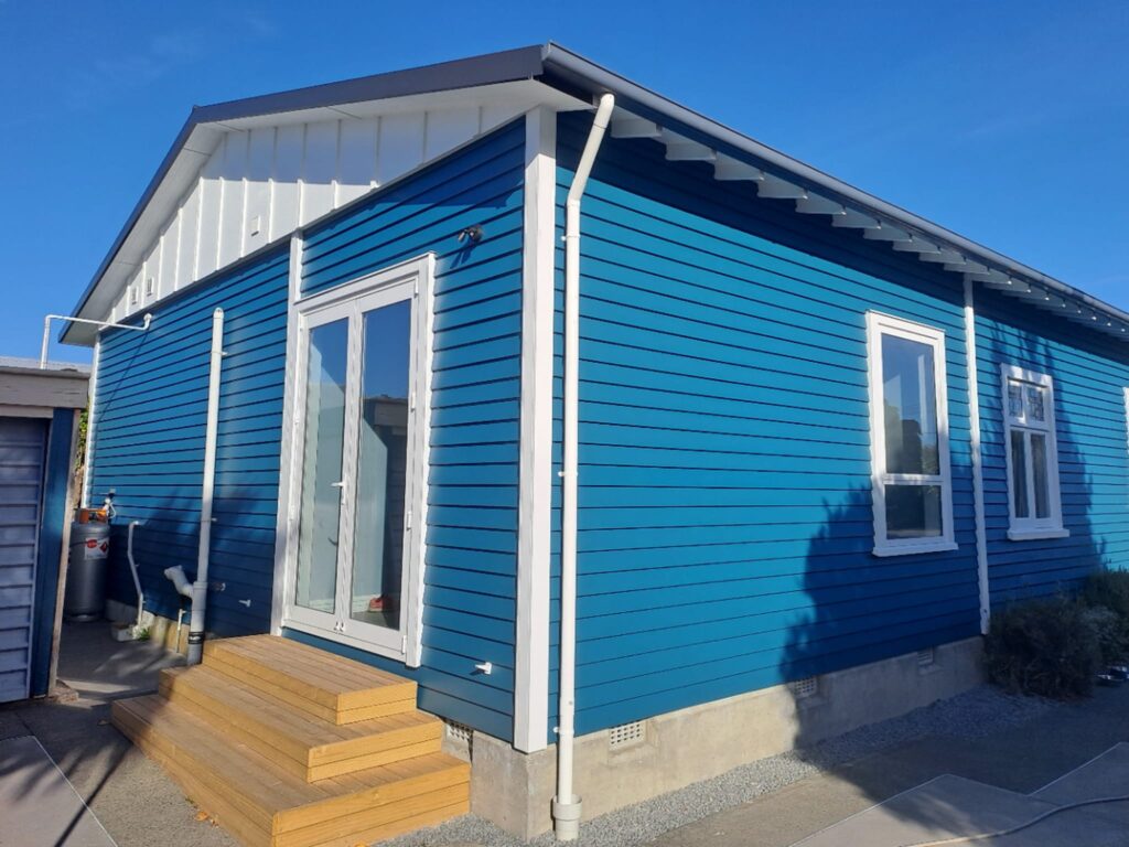 Completed home renovation featuring fresh weatherboard and new French doors, part of a full house renovation by Stanton Builders.