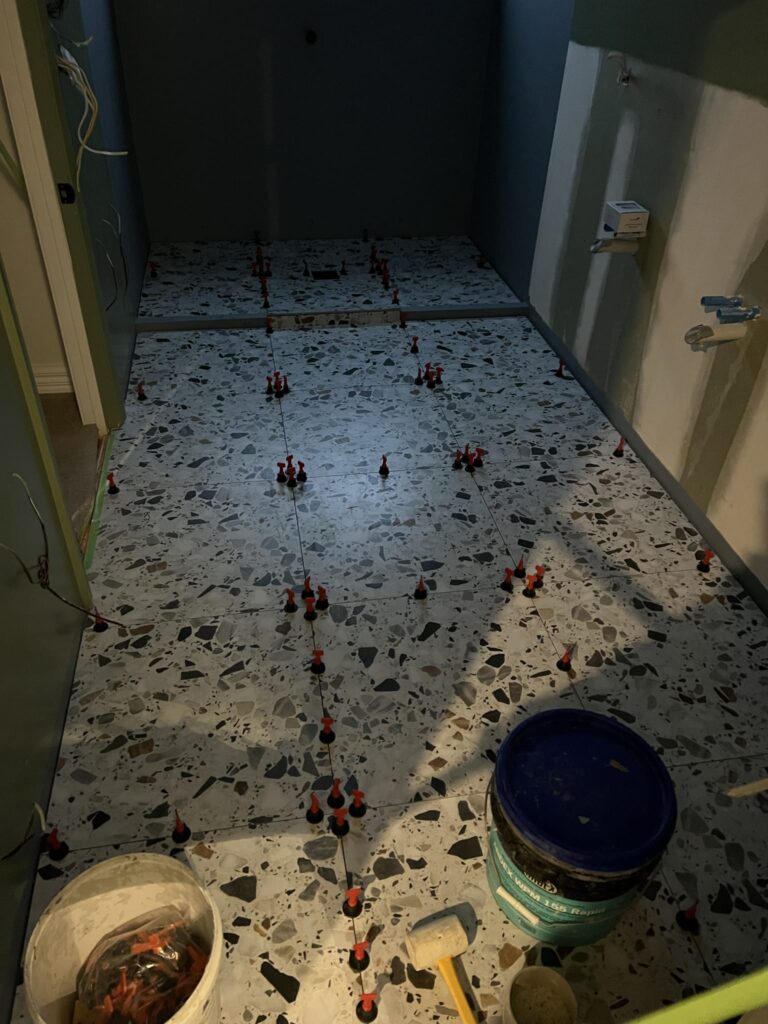 Floor tiles being installed during a bespoke bathroom renovation by Stanton Builders, expert bathroom and home builders in Canterbury.